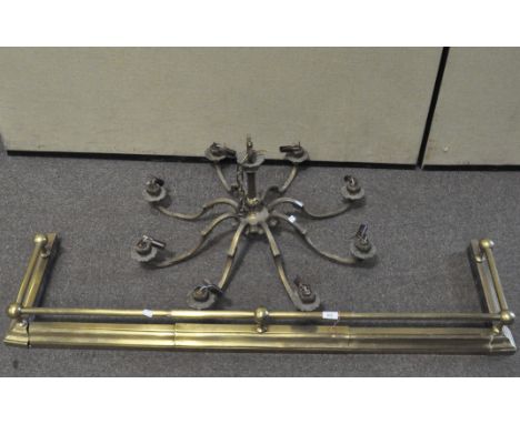 An eight light brass chandelier and a brass fender with ball finials, the first 76 cm wide x 39 cm high (exc chain)