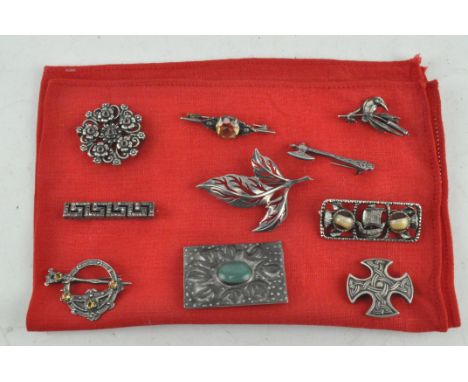 Ten assorted brooches including a Celtic cross, a kingfisher and an axe