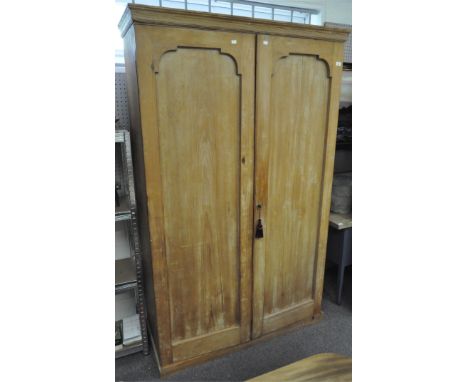 A Victorian stripped pine two door wardrobe with hat shelf above two hanging/shelving spaces, 205 cm x 123 cm x 50 cm