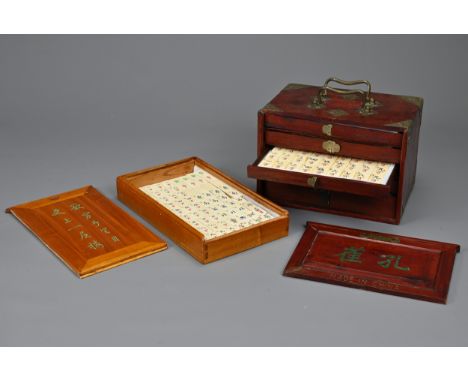 TWO CHINESE MAHJONG SETS, 20TH CENTURY. Both fully complete with tiles in wood boxes. (2) One metal piece of handle missing t