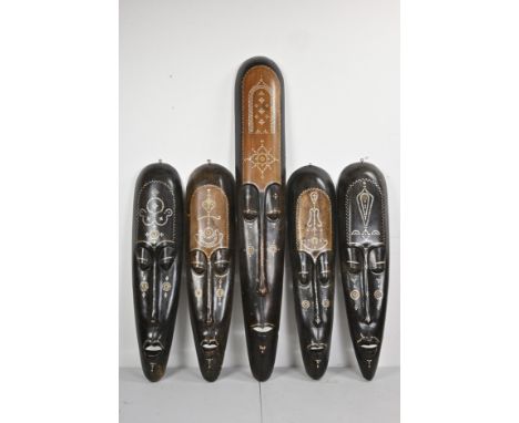 FIVE LARGE DECORATIVE HARDWOOD AFRICAN TRIBAL STYLE MASKS INLAID WITH MOTHER OF PEARL AND COINS. 100cm - 150cm lengths. (5) T