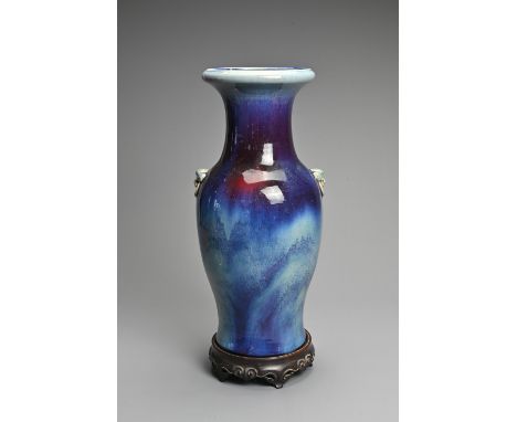 A CHINESE FLAMBE GLAZED PORCELAIN VASE, 20TH CENTURY. Of baluster form with lion mask ring handles. Four character mark to ba