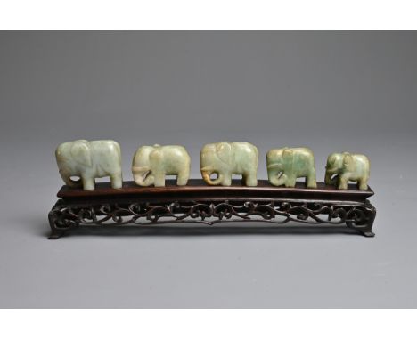 CHINESE JADE ELEPHANT GROUP ON WOODEN STAND, 19/20TH CENTURY. A procession of five individually carved nephrite jade elephant