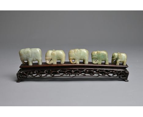 CHINESE JADE ELEPHANT GROUP ON WOODEN STAND, 19/20TH CENTURY. A procession of five individually carved nephrite jade elephant