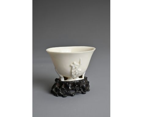 A CHINESE BLANC DE CHINESE PORCELAIN LIBATION CUP, 17TH CENTURY. With applied floral sprays on an openwork base. Together wit