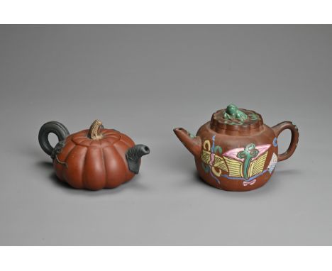 TWO CHINESE YIXING POTTERY TEA POTS, EARLY 20TH CENTURY. A rounded tea pot decorated with green, yellow and blue enamels surm