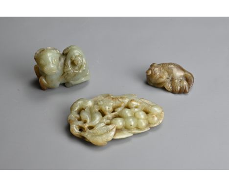 THREE CHINESE CELADON JADE CARVINGS. To include a recumbent buffalo with boy; A lion and bat group pendant; Together with a l