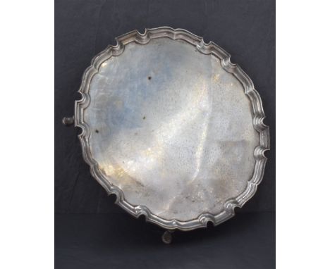 A George V silver salver, of circular form with moulded 'Chippendale' rim, raised on four short legs with pad feet, marks for