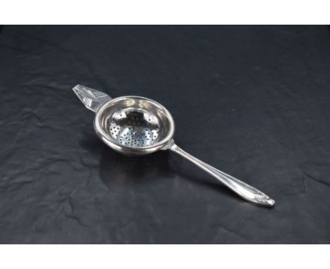 An Edward VIII silver tea strainer, of traditional design with Art Deco motifs, marks for Sheffield 1936, maker Angora Silver