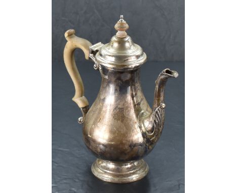 A Queen Elizabeth II silver coffee pot, of baluster form with domed and hinged finial topped cover over a scroll handle and m