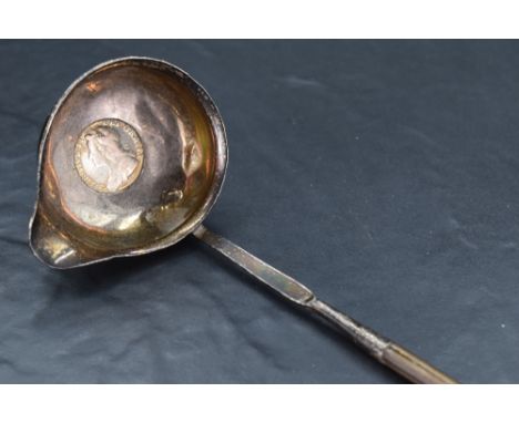 A George III white metal and baleen toddy ladle, of traditional for with twisted stem and spouted circular bowl engraved with