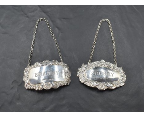 Two Elizabeth II silver spirit labels, of traditional design named Sherry &amp; Brandy, marks for London 1974, maker R&amp;K,