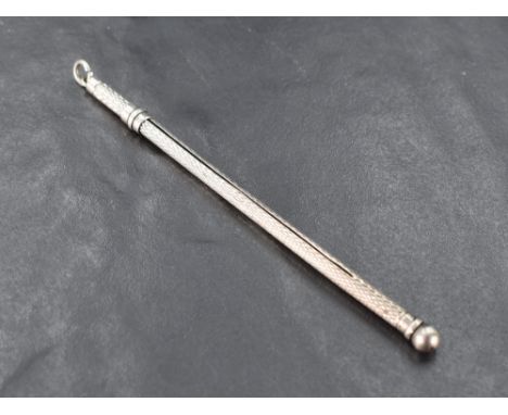 An early 20th century silver propelling cocktail swizzle stick, engine-turned with sliding action, marks for Birmingham 1913,