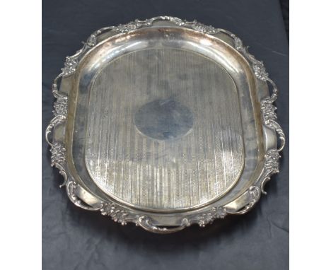 An Edwardian silver tray, of rounded rectangular form, having a foliate scroll moulded rim enclosing engine-turned decoration