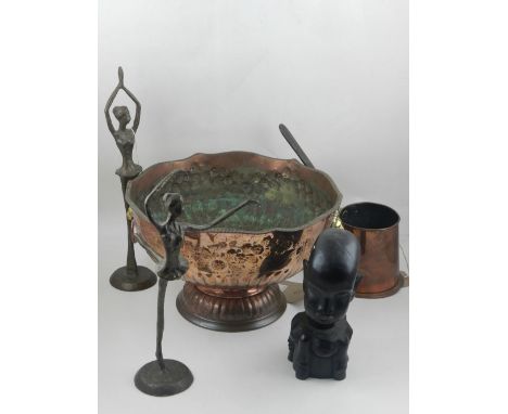 A copper bowl, having twin lion mask ring handles, repousse embossed with flowers and foliage, raised on a circular stepped b