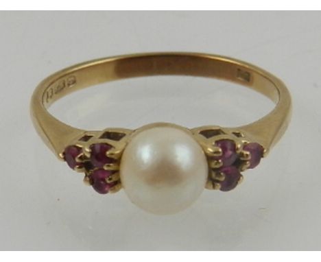 A 9 carat yellow gold, pearl, and ruby ring, set single pearl flanked by six small rubies. 