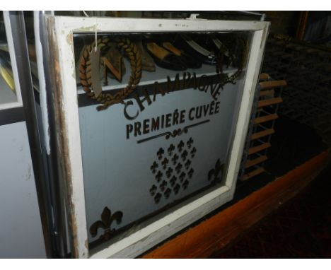 A champagne premiere cuvee advertising glass panel, set in a white painted frame.  H: 75cm W: 75cm