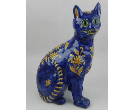 A Galle style ceramic model of a cat, decorated with orange flowers on a cobalt blue ground. H: 33cm