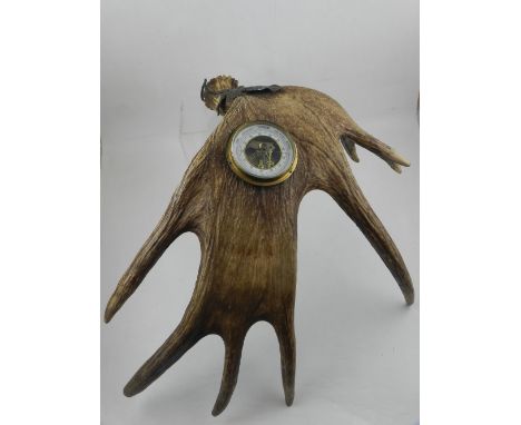An early 20th century German aneroid barometer mounted in an antler, with an oak leaf suspension mount, H. 62cm