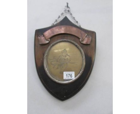 A vintage fire fighters award in brass and copper on an oak shield