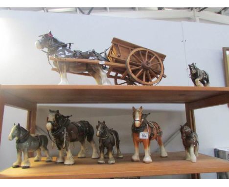 A collection of ceramic shire horses including one pulling dray