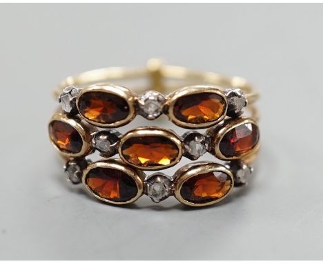 A late Victorian yellow metal, garnet and diamond chip cluster set triple shank ring, size M, gross weight 3.6 grams.