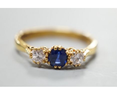 A modern 18ct gold, sapphire and diamond set three stone ring, size S, gross weight 4.4 grams, the sapphire weighing approx. 