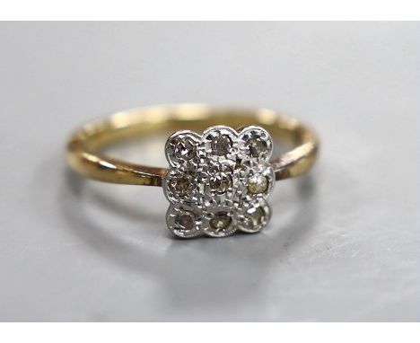 A 1920's 18ct and nine stone diamond cluster set tablet ring, size R, gross weight 4 grams.