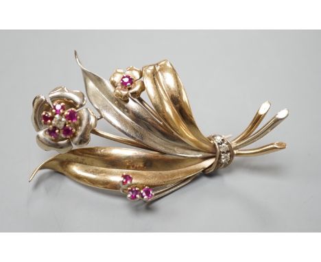 A two colour yellow metal, ruby and diamond cluster set floral spray brooch, 51mm, gross weight 8.2 grams.