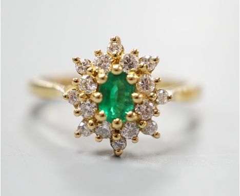 A modern 18ct gold, emerald and diamond set star shaped cluster ring, size L/M, gross weight  3.8 grams, the emerald weighing