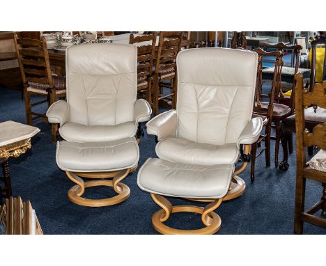 Pair of Cream Leather Stressless Chairs, with matching foot stools, on light wood circular bases.  Excellent condition. Has i