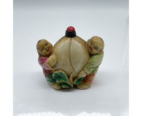 This small Chinese snuff bottle features a delightful depiction of two children holding a large peach, symbolizing immortalit