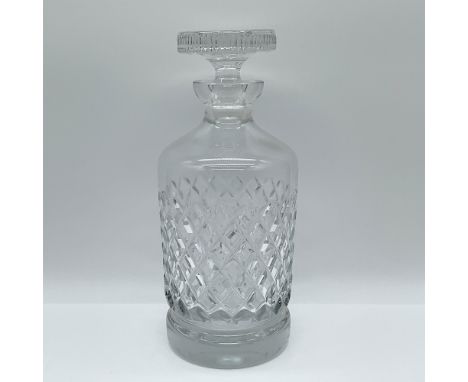 This elegant cut glass decanter features a timeless design with intricate diamond and crosshatch patterns, showcasing skilled