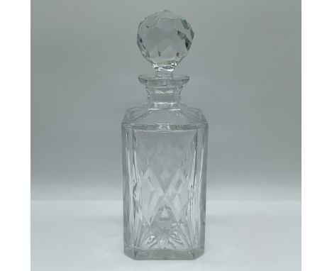 This elegant cut glass decanter features a diamond-patterned design with a faceted stopper. The decanter stands 10.75 inches 