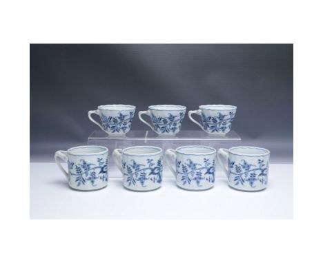 A set of seven Blue Danube porcelain cups featuring the classic Blue Onion (Zwiebelmuster) pattern in cobalt blue on white. S