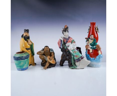 A collection of four Chinese ceramic pieces, including three intricately detailed figures and a vibrant red vase adorned with