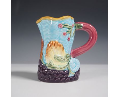 A vibrant antique majolica pitcher featuring an ocean-inspired shell and seaweed motif. The pitcher showcases a striking turq