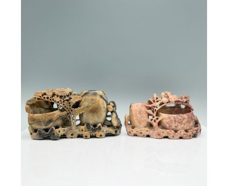 A pair of intricately carved Chinese soapstone brush pots, showcasing natural stone hues of gray-black and reddish-brown. Bot