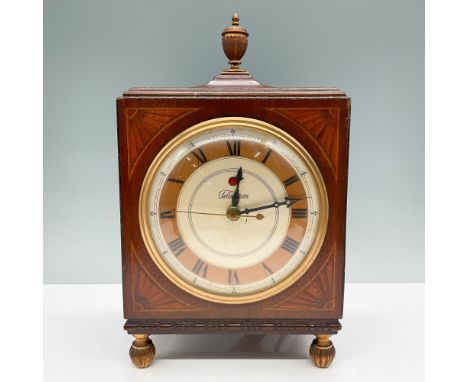 This vintage Telechron electric mantle clock features a solid wood case with decorative carvings, a finial top, and four orna