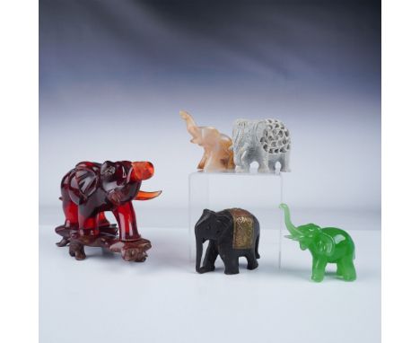 A charming collection of 5 elephant figurines crafted from various materials. The largest figurine is a striking red resin el