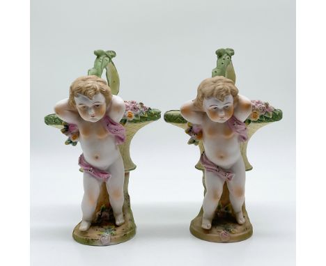 This pair of porcelain cherub vases by Ardalt, made in Japan, features a charming design of cherubic figures leaning against 