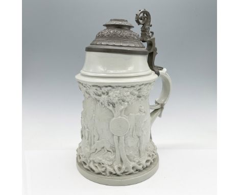 Antique German stoneware stein featuring a detailed relief hunting scene, complete with hunters, a dog, and a target. The ste