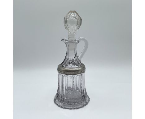 This elegant cut glass decanter stands 10 inches tall and features a beautifully faceted design with vertical ribbing and int