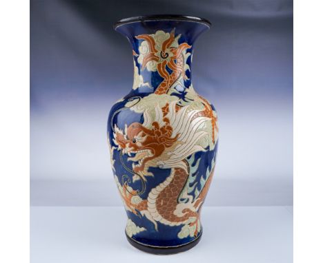 A large hand-painted ceramic vase adorned with a striking dragon motif set against a rich cobalt blue background. This piece 