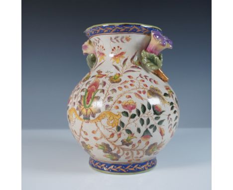 Decorative ceramic vase by Winward, featuring an intricate floral and bird motif with sculpted double flower handles. The bod