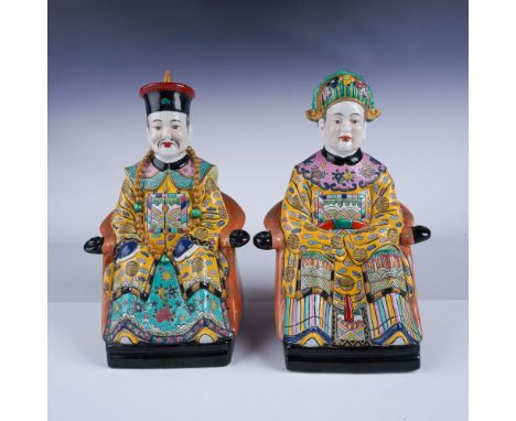 A beautiful pair of vintage ceramic figurines, depicting a Chinese emperor and empress seated in regal attire. Largest figuri