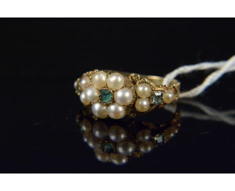 An antique unmarked yellow metal pearl and emerald set ring with floral form settings, heavily engraved shoulders, size K, we