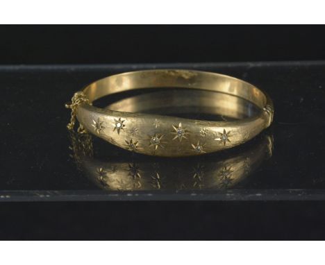 A 9ct gold bangle set with small diamonds in star cut setting, weight approx 15.5g