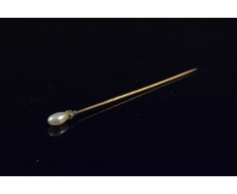 An unmarked yellow metal diamond and pearl stick pin