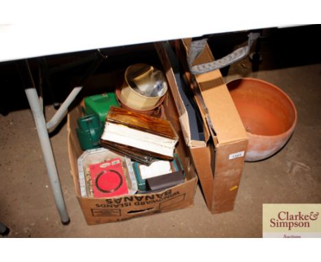 A box of various garden items and a terracotta planter